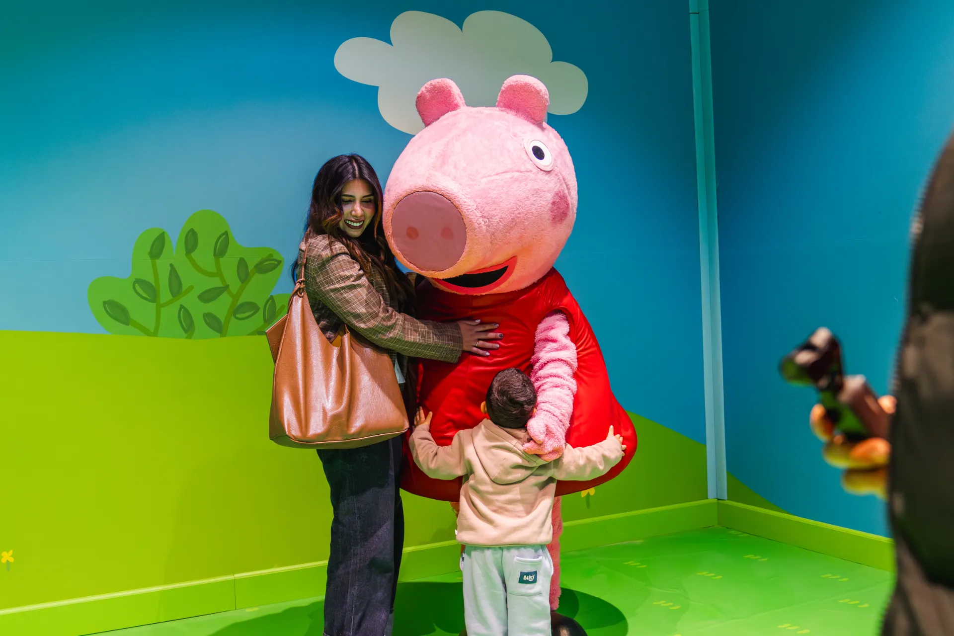Familia abrazando a Peppa Pig